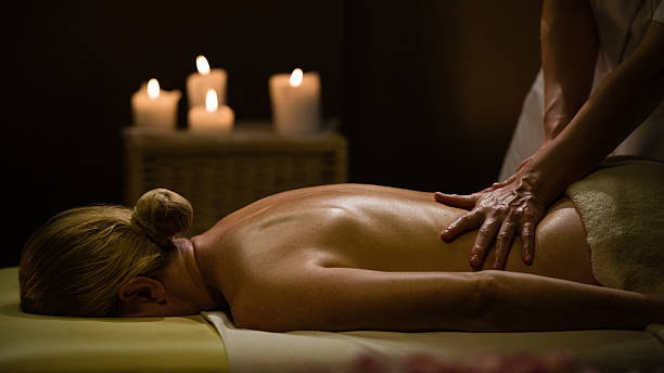 Un masseur masse le corps nu d'une femme en étant très au contact de son corps, lors d'un massage body body!