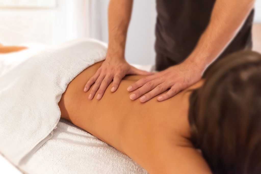 Un praticien se connecte à l'énergie de sa cliente avant de commencer son massage énergétique!